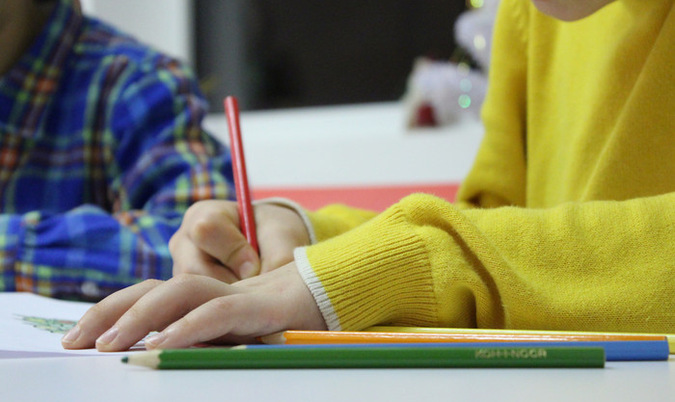 Barn skriver med en penna