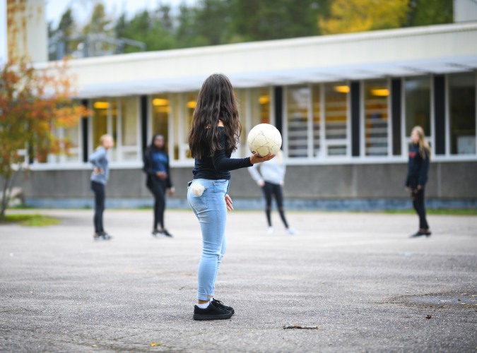 Tjejer spelar fotboll på skolgården