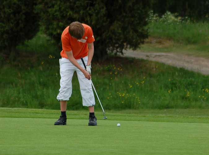 Ung kille spelar golf