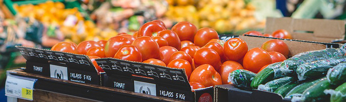 Röda tomater ligger till vänster och gröna gurkor till höger.