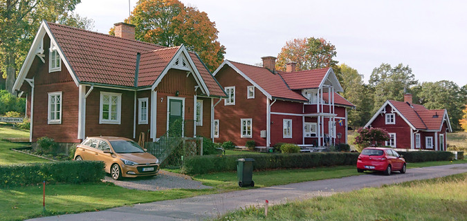 Röda hus vid grusväg i Borggård.