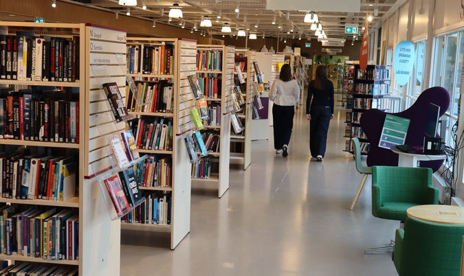På bildens syns två personer som går i en av korridorerna på huvudbiblioteket i Finspångs kommun.